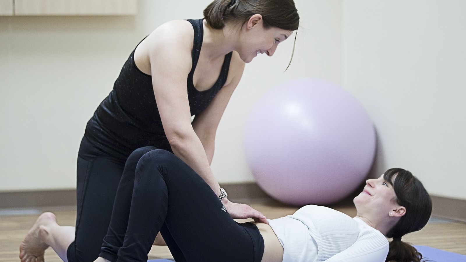 An Optimum physiotherapist guiding a client through a pelvic floor assessment