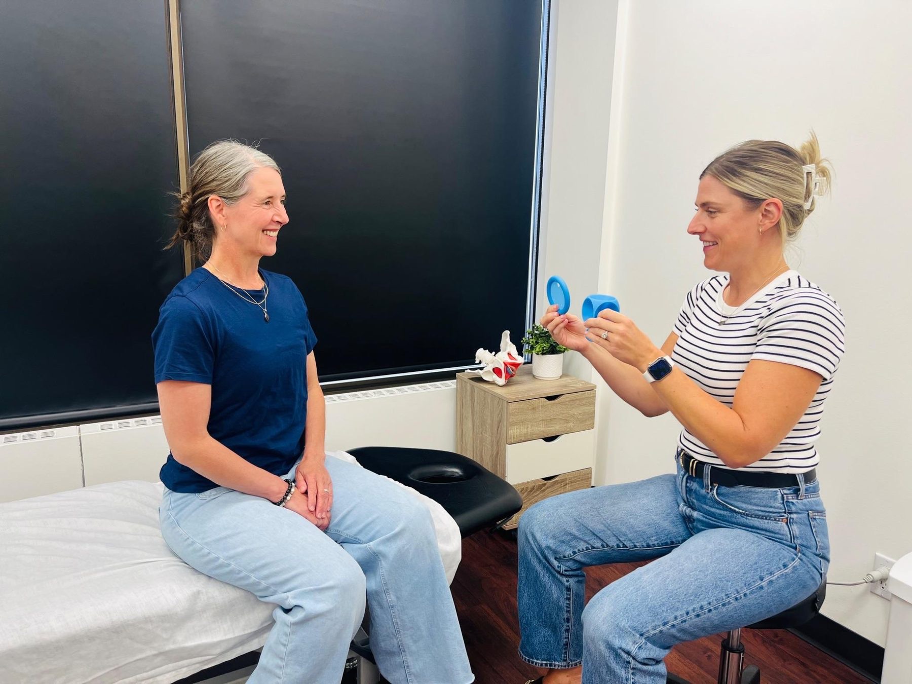 An Optimum physiotherapist showing a client a pessary during a fitting consultation